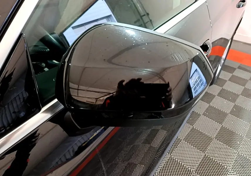 Rétroviseur côté gauche noir brillant d'un Audi Q3 35 TDI 150 S tronic Business Line, vue rapprochée en intérieur.