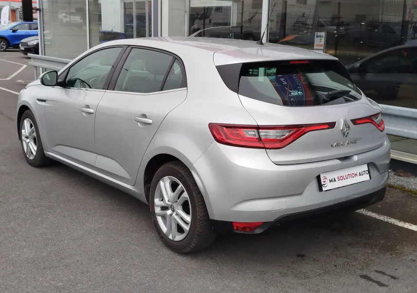 Vue 3/4 arrière droite d'une Renault Mégane gris titanium de 2018, avec feux arrière LED et jantes alliage.