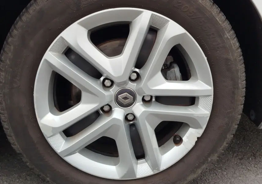 Gros plan sur la jante alliage argentée avec logo Renault au centre, montée sur un pneu Michelin d'une Renault Mégane gris titanium.