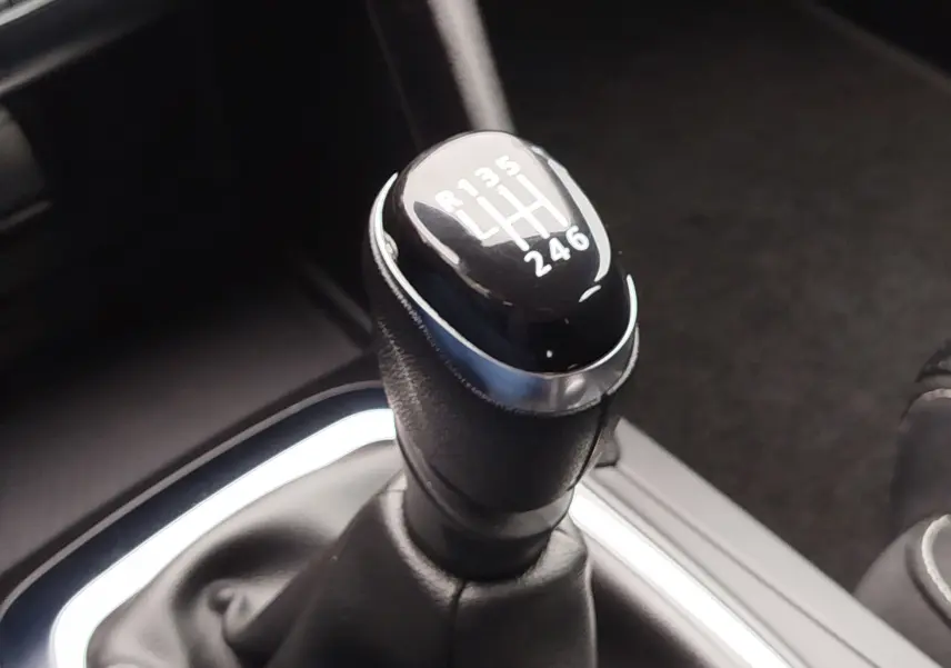 Gros plan sur le levier de vitesses manuel noir de la Renault Mégane 1.5 dCi, montrant les rapports gravés en blanc.