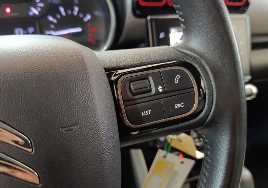 Gros plan sur le volant cuir noir de la Citroën C3 Aircross 2021, avec commandes audio et téléphone intégrées.