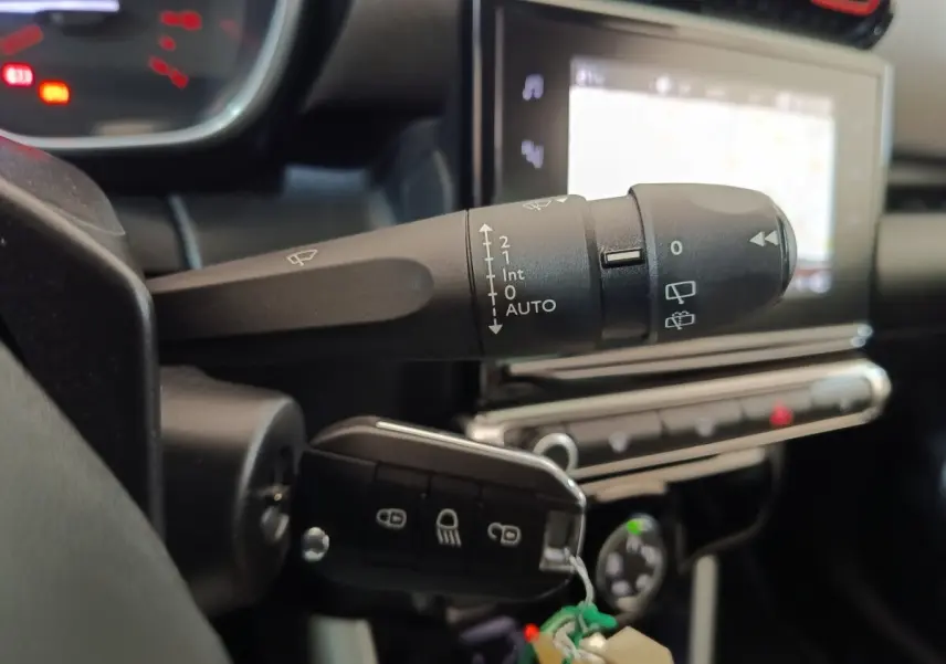 Gros plan sur la commande d’essuie-glace et la clé de contact dans l’habitacle beige du Citroën C3 Aircross 2021.