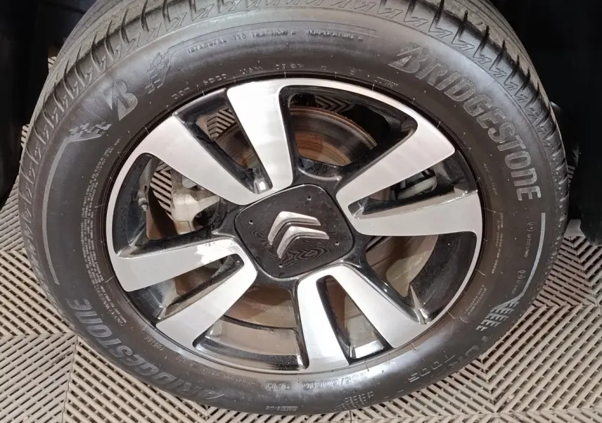 Gros plan sur la jante alliage bicolore et le pneu Bridgestone d’un Citroën C3 Aircross beige.
