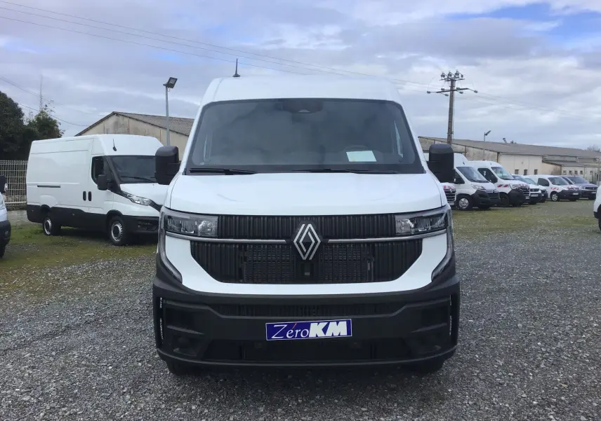 Vue frontale d’un Renault Master blanc 2026 avec calandre noire et logo Renault bien visible, sur un parking extérieur.