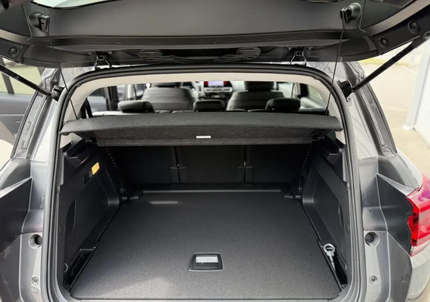 Coffre ouvert vu de l’arrière d’un Citroën C5 Aircross gris platinium métal, montrant un espace de chargement spacieux et propre.