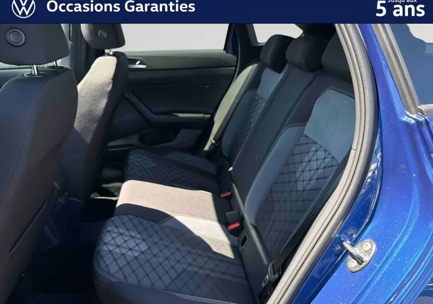 Vue intérieure côté droit sur la banquette arrière du Volkswagen Taigo bleu avec sellerie tissu à motifs géométriques.