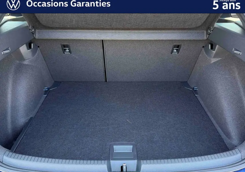 Coffre ouvert en vue arrière d’un Volkswagen Taigo bleu métallisé, montrant un espace de chargement propre et spacieux.