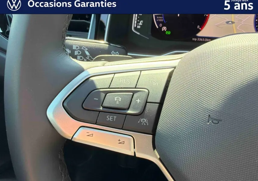 Gros plan sur le volant cuir multifonctions du Volkswagen Taigo 2025 avec commandes d’aide à la conduite intégrées.