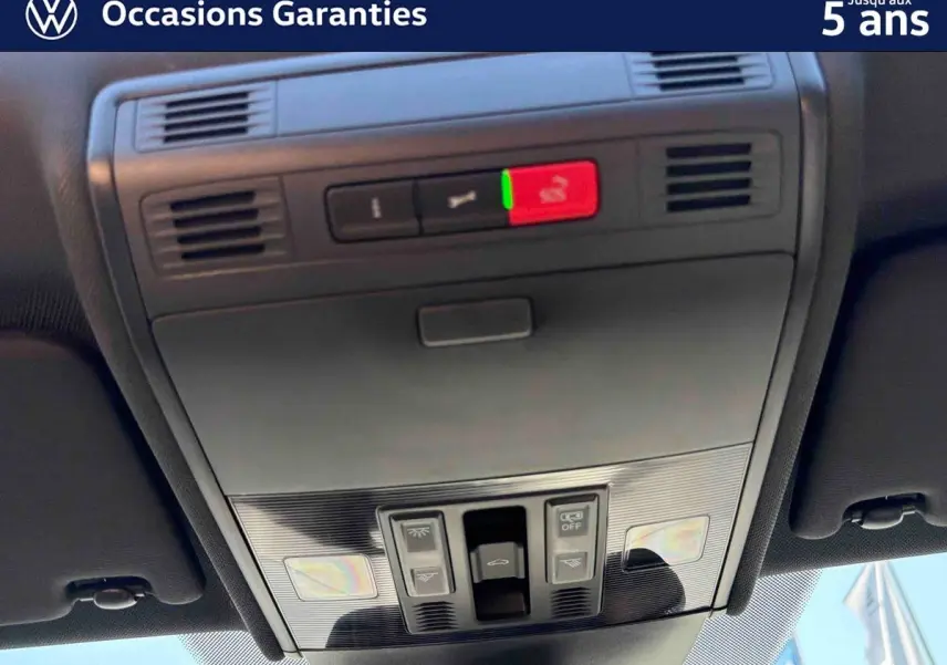 Vue en gros plan du panneau de commandes du toit ouvrant électrique en verre du Volkswagen Taigo bleu.