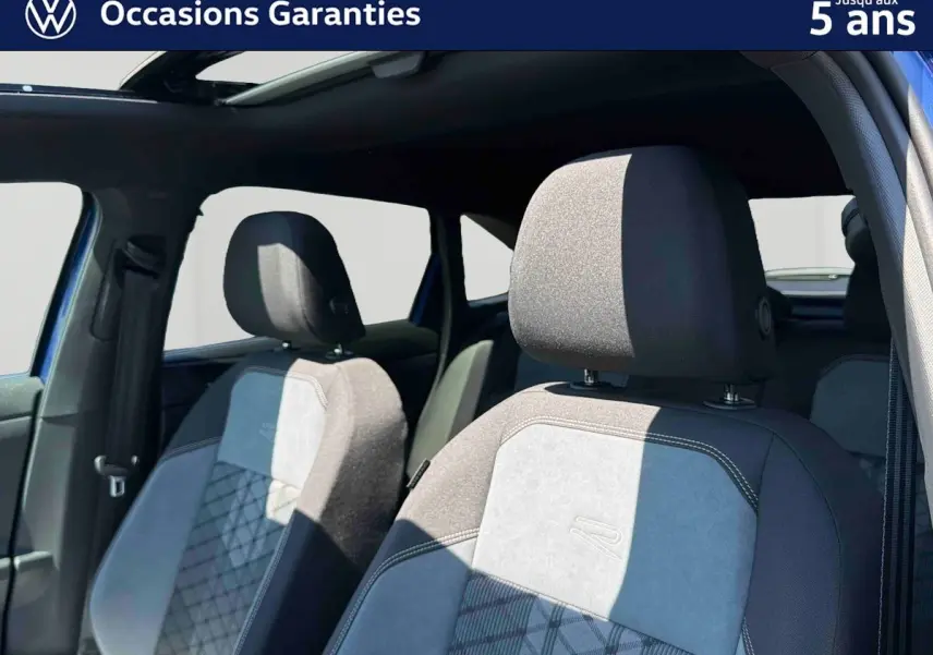 Vue intérieure sur les sièges avant gris et noirs du Volkswagen Taigo 2025 avec toit ouvrant électrique en verre.