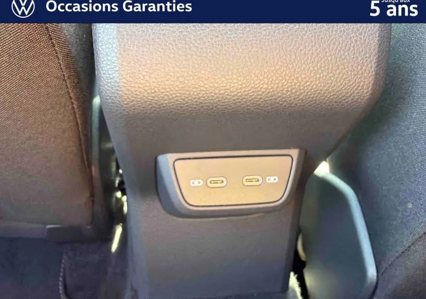 Gros plan sur la console centrale arrière du Volkswagen Taigo bleu, montrant deux ports USB-C pour recharge.