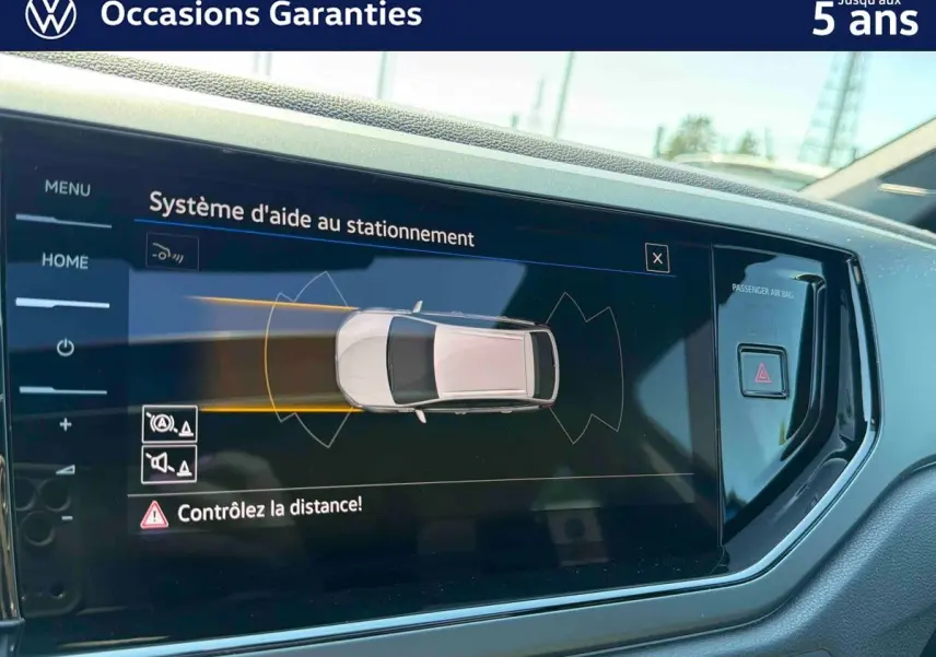 Écran tactile intérieur du Volkswagen Taigo bleu 2025 montrant le système d'aide au stationnement.