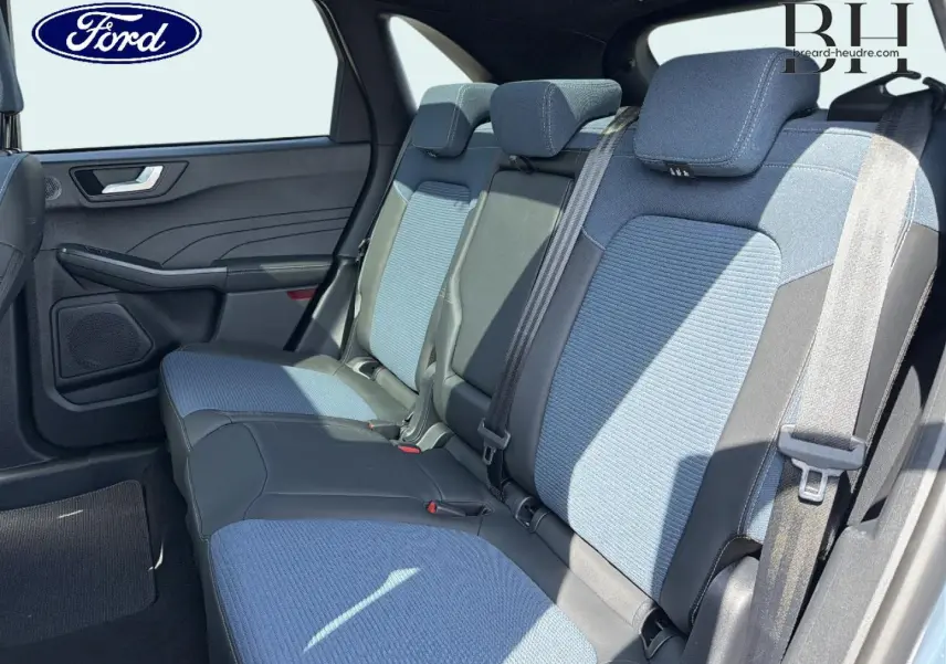 Vue latérale intérieure sur la banquette arrière bleu et noir du Ford Kuga 2026 avec ceintures et appuie-têtes.