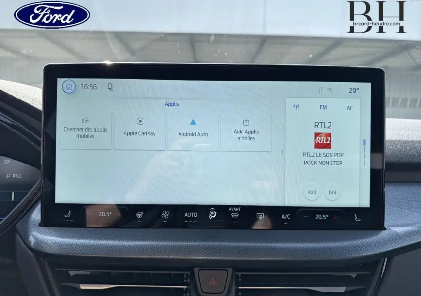 Vue intérieure centrée sur l'écran tactile du tableau de bord du Ford Kuga 2026, affichant les applications multimédia.