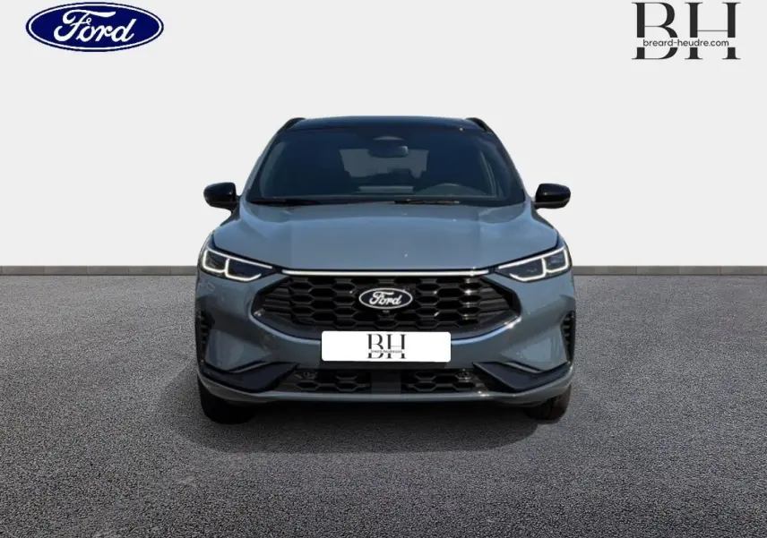 Vue frontale d'un Ford Kuga bleu métallisé avec calandre noire et phares LED allumés sur fond neutre.