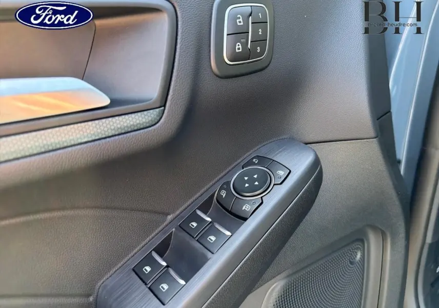 Détail de la porte avant gauche du Ford Kuga 2026 avec commandes de vitres et verrouillage en plastique noir.