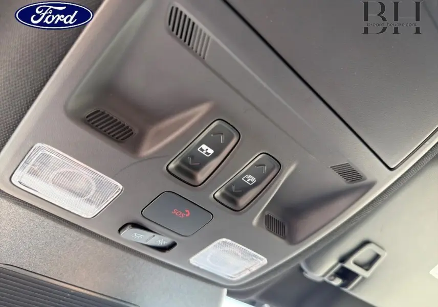 Vue en plongée sur les commandes du toit ouvrant panoramique et l’éclairage intérieur du Ford Kuga bleu 2026.