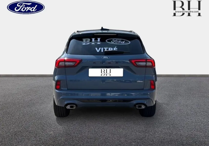 Vue arrière d'un Ford Kuga bleu métallisé 2026 avec double sortie d'échappement et toit panoramique visible.
