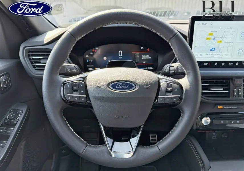 Vue intérieure centrée sur le volant noir multifonction du Ford Kuga 2026 avec écran tactile et tableau de bord numérique.