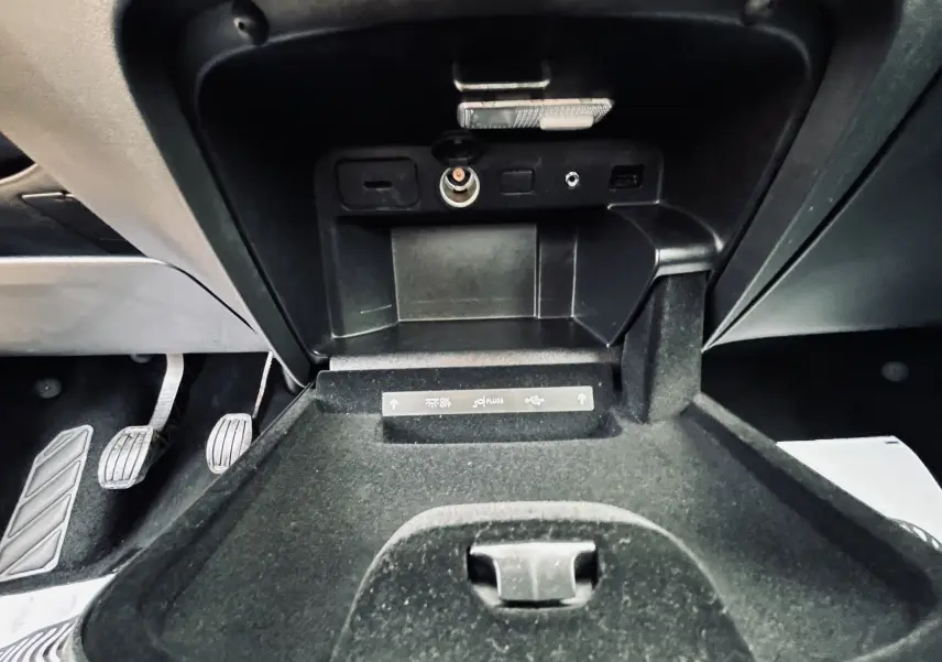 Gros plan sur la console centrale ouverte du Citroën C4 Picasso gris, montrant prises USB et allume-cigare.