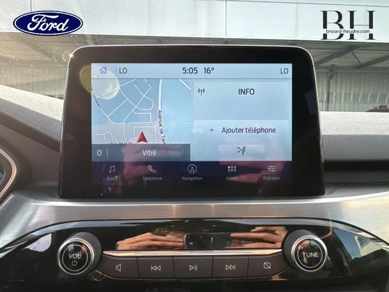 Écran tactile central du tableau de bord du Ford Kuga 2023 gris Solar, affichant la navigation GPS et commandes audio.