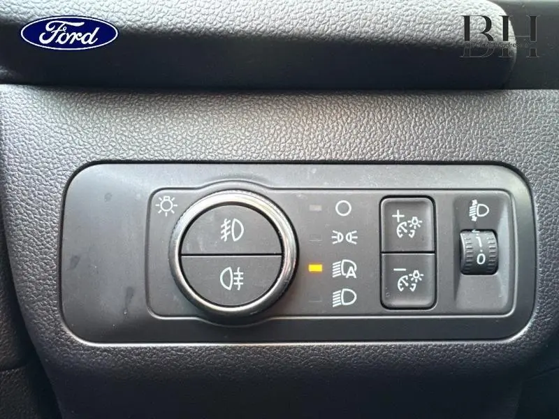 Gros plan sur les commandes d'éclairage du Ford Kuga 2023, avec réglages de phares et feux antibrouillard.