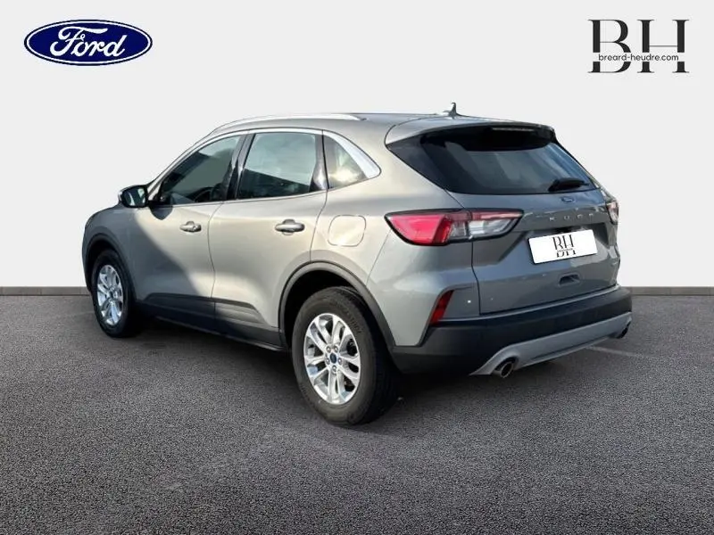 Ford Kuga gris Solar métallisé vu en 3/4 arrière droit, avec jantes alu et feux arrière LED distinctifs.