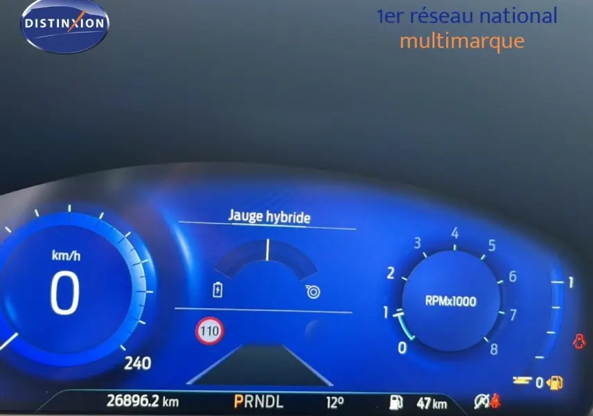 Tableau de bord numérique bleu du Ford Puma 2024, affichant la jauge hybride et compteur à 0 km/h, vue de face.