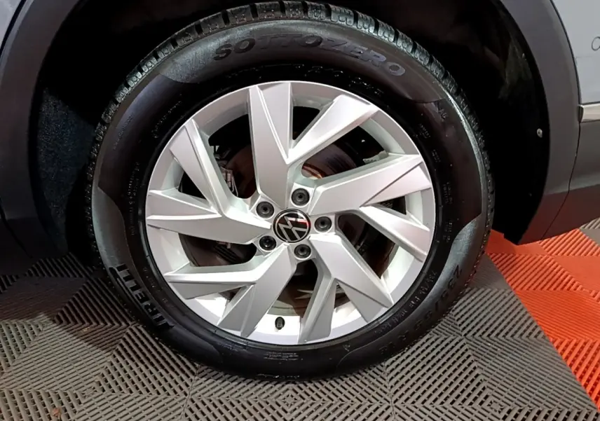 Gros plan sur la roue avant droite du Volkswagen Tiguan gris foncé, jante alliage argentée et pneu Pirelli Sottozero.