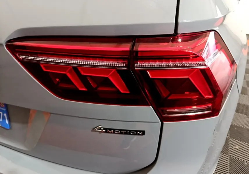Feu arrière droit rouge et badge 4Motion sur le coffre gris foncé d'un Volkswagen Tiguan 2021.