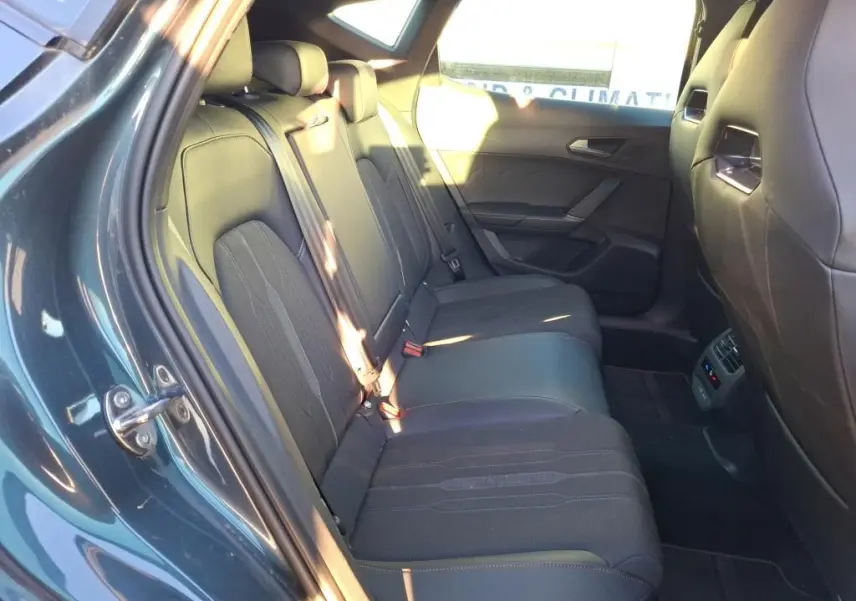 Vue intérieure côté gauche des sièges arrière noirs en tissu du CUPRA Formentor gris foncé 2023, avec commandes de climatisation visibles.