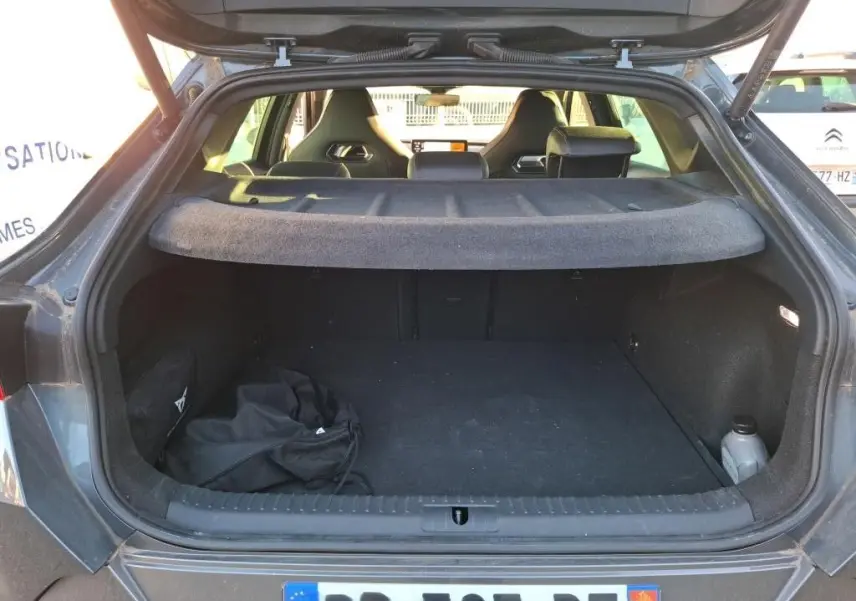 Coffre ouvert vu de l'arrière d'une CUPRA Formentor gris foncé 2023, avec cache-bagages et sièges noirs visibles.