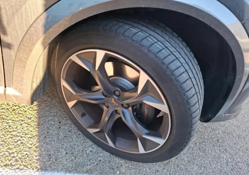 Gros plan sur la roue avant gauche gris foncé d’un CUPRA Formentor 1.4 e-HYBRID 245 DSG avec jante noire et logo CUPRA.