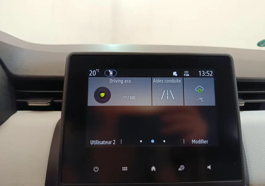 Écran tactile central de la Renault Clio blanc, affichant les aides à la conduite et la température intérieure.