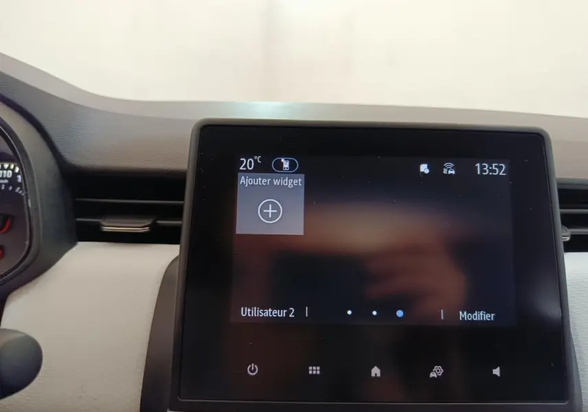 Écran tactile central de 7 pouces de la Renault Clio blanche, affichant le menu principal avec options widget.