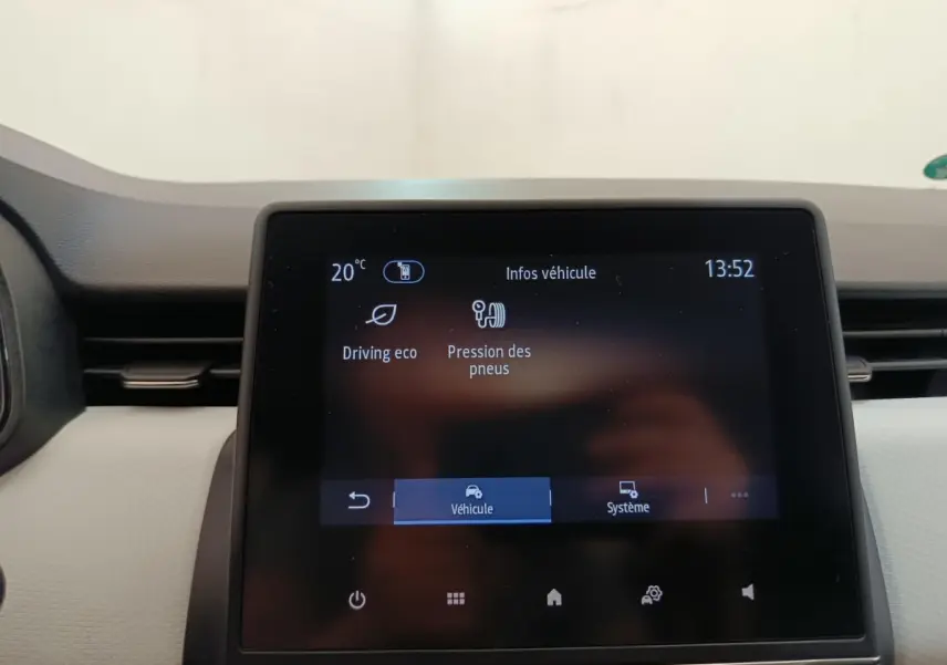 Écran tactile central affichant les infos véhicule dans l’habitacle d’une Renault Clio blanche, vue de face.