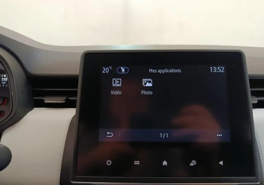 Écran tactile central de la Renault Clio blanc 2023 affichant les applications vidéo et photo.
