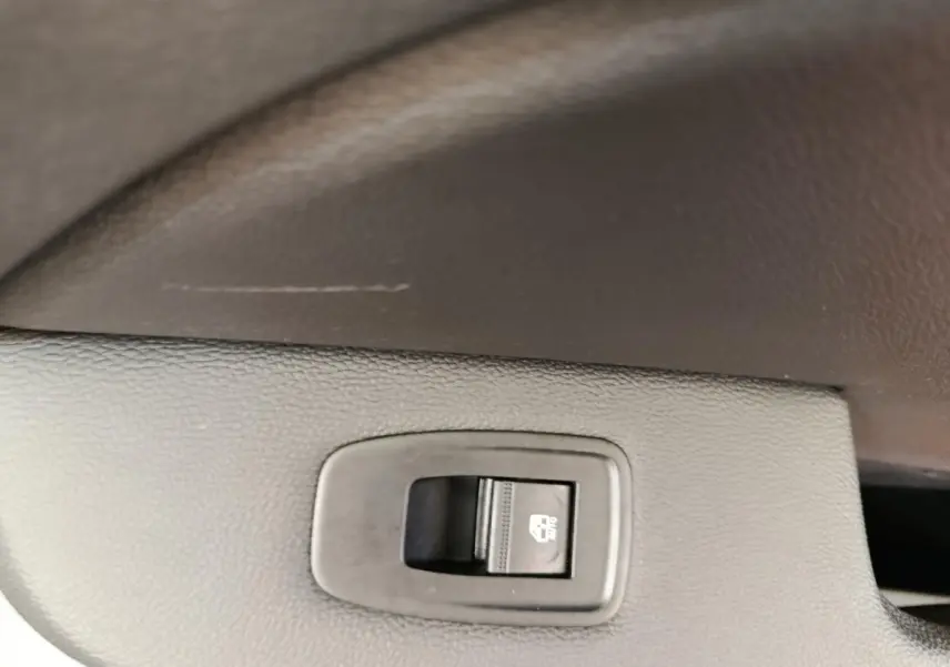 Gros plan sur l'interrupteur de verrouillage des vitres arrière dans une Renault Clio blanche Evolution TCe 100 GPL.