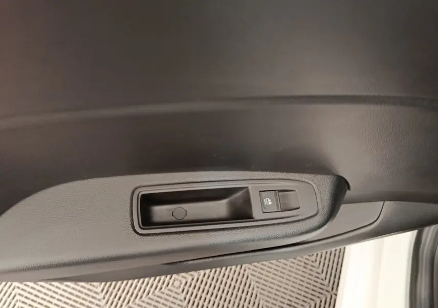 Détail de la poignée intérieure noire de porte côté conducteur d'une Renault Clio blanche 2023.