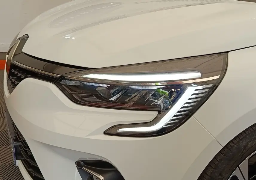 Gros plan sur le phare avant droit blanc de la Renault Clio Evolution TCe 100 GPL 2023 avec LED distinctive.