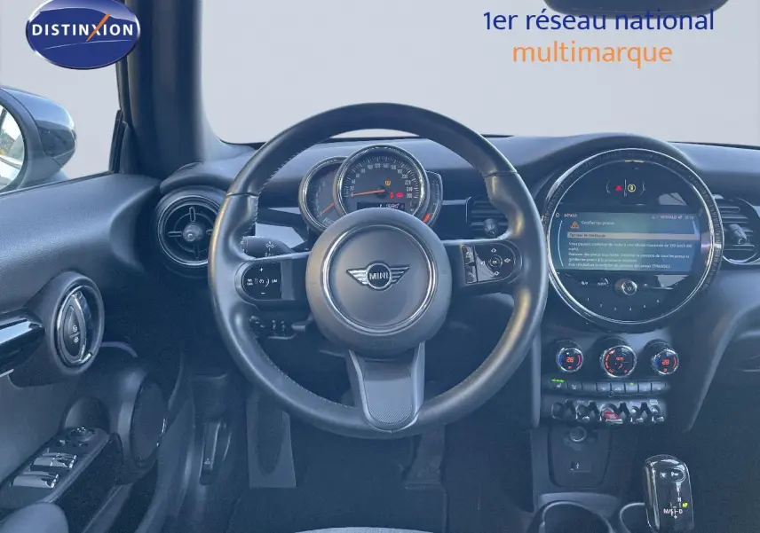 Vue intérieure centrée sur le volant et tableau de bord de la MINI Cabriolet F57 noir avec écran digital et commandes modernes.