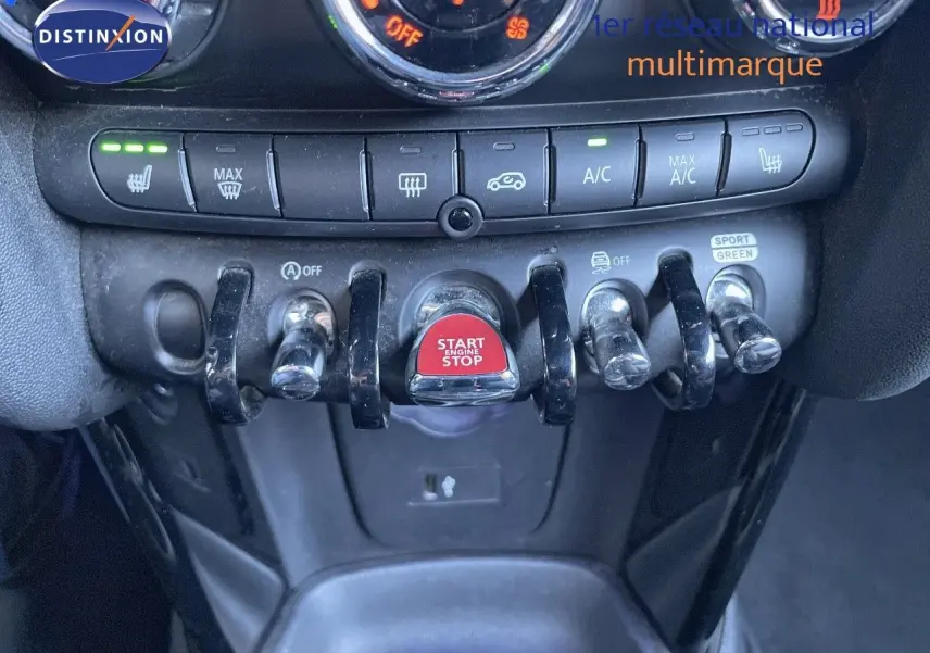 Détail du tableau de bord de la MINI Cabriolet F57 2023, mettant en valeur les commandes de climatisation et le bouton start/stop rouge.