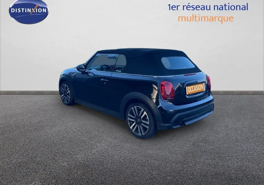 Vue 3/4 arrière droite d'une MINI Cabriolet F57 noire Midnight Metal avec capote noire et jantes bi-ton.