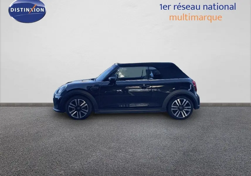 Profil côté gauche d'une MINI Cabriolet F57 noire Midnight Metal avec capote fermée sur fond neutre.