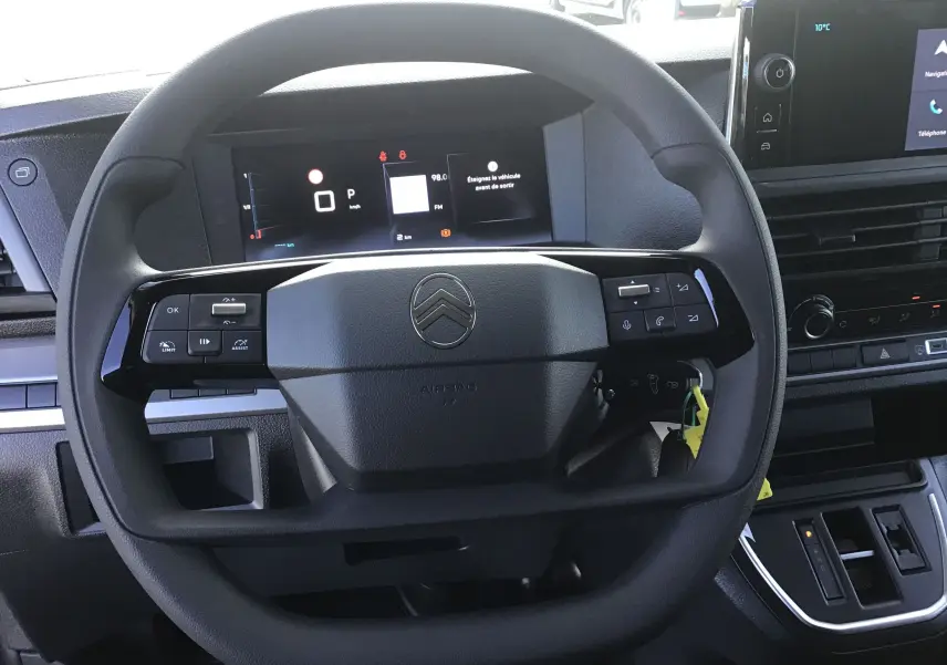 Vue rapprochée du volant noir du Citroën Jumpy XL gris titane, avec tableau de bord numérique et écran central tactile.