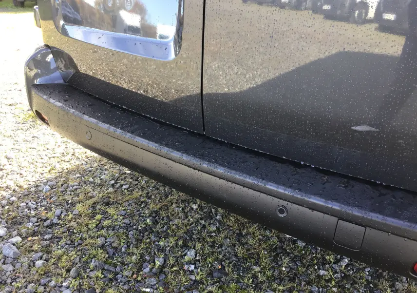 Gros plan sur la partie arrière droite gris titane d'un Citroën Jumpy Cabine Approfondie avec capteurs de recul visibles.