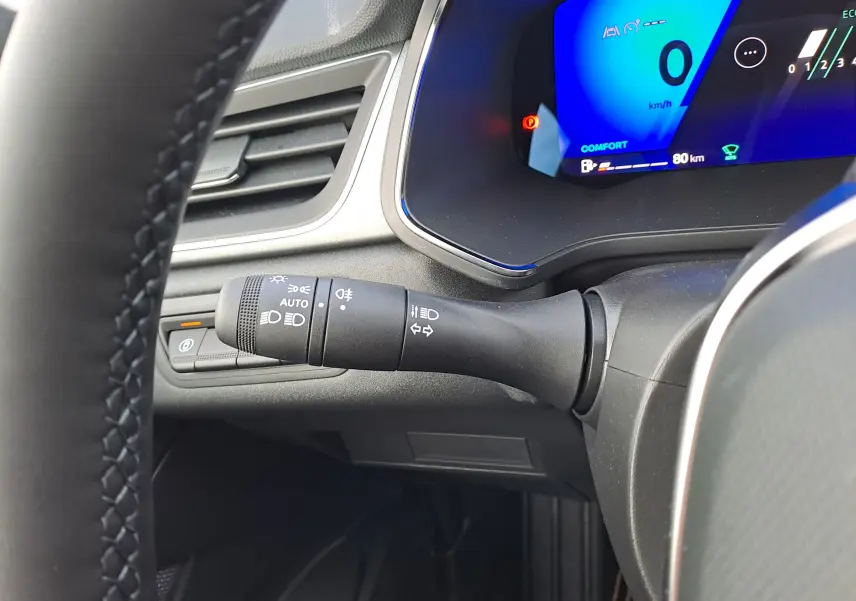 Vue rapprochée du combiné d'instruments bleu et du commodo d'éclairage noir dans l'habitacle du Renault Symbioz gris.