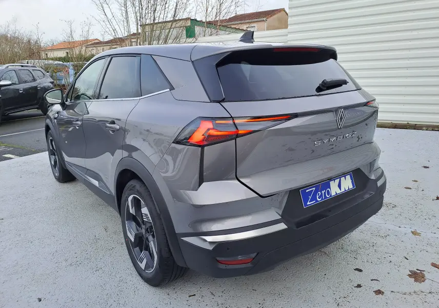 Vue 3/4 arrière droite d'une Renault Symbioz gris Cassiopée avec feux arrière LED et toit noir brillant.