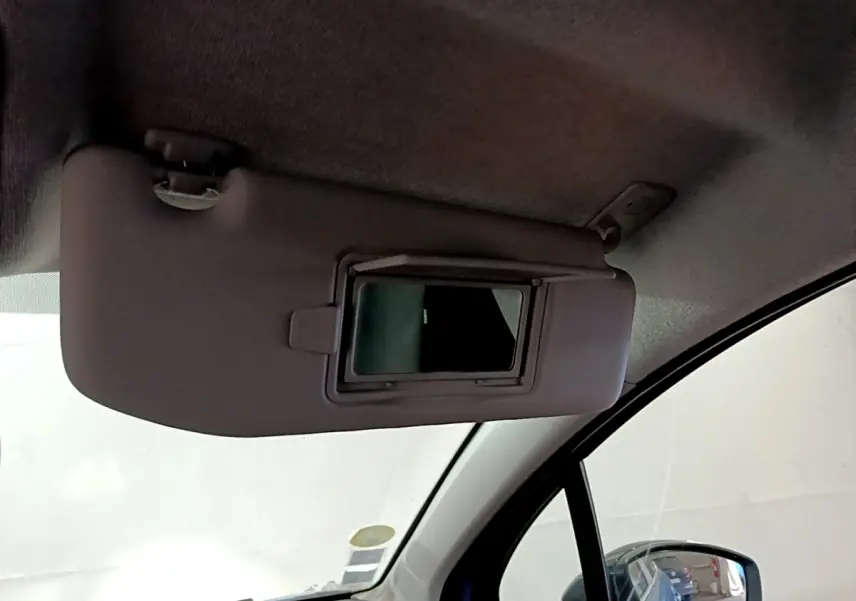 Miroir de courtoisie ouvert sur le pare-soleil côté conducteur d'une Citroën C3 2017 bleu, vue intérieure avant droite.