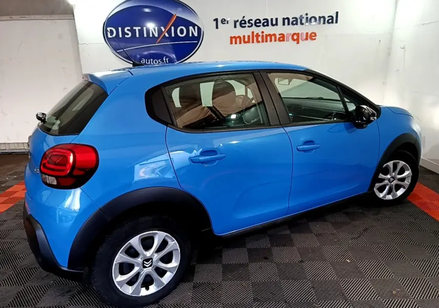 Vue latérale droite d'une Citroën C3 bleu vif 2017 en intérieur, soulignant ses lignes compactes et ses jantes argentées.